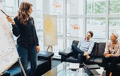 LBS Immobilienberater mit Gebietsleiterin und Baufinanzierungsberaterin im Weiterbildungsgespräch