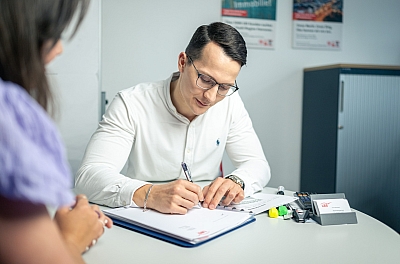 LBS-Berater-macht-sich-im-Gespräch-mit-einer-Kundin-Notizen LBS-Berater macht sich im Gespräch mit einer Kundin Notizen.